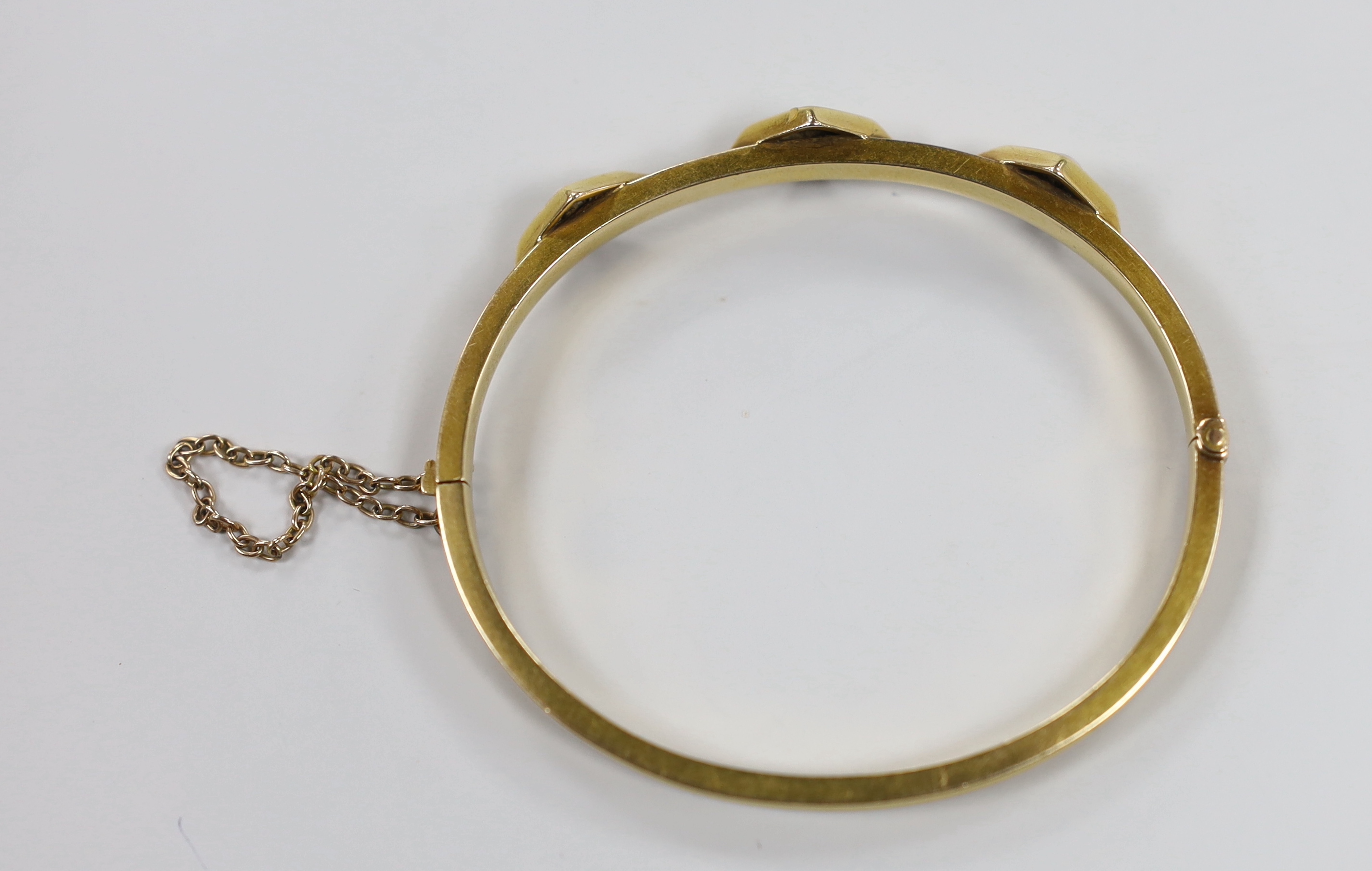 An Edwardian reeded yellow metal, turquoise and split pearl set three stone hinged bangle, interior diameter 56mm, gross weight 11.6 grams.